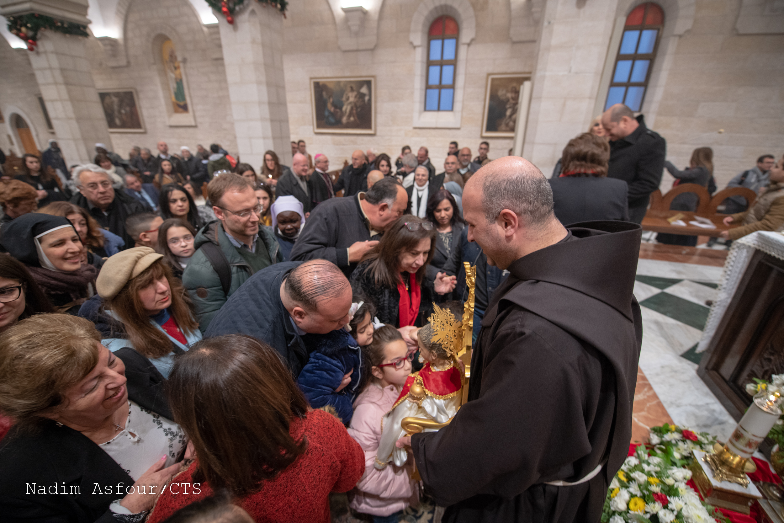 Epiphany 2020: parishioners of St. Catherine's in Bethlehem venerate the statue of Baby Jesus, held up by parish priest Br. Rami Asakrieh